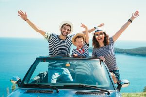 Happy family travel by car to the sea. People having fun in cabr