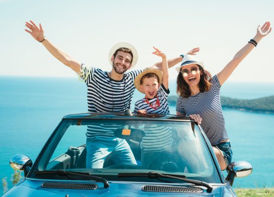 Happy family travel by car to the sea. People having fun in cabr